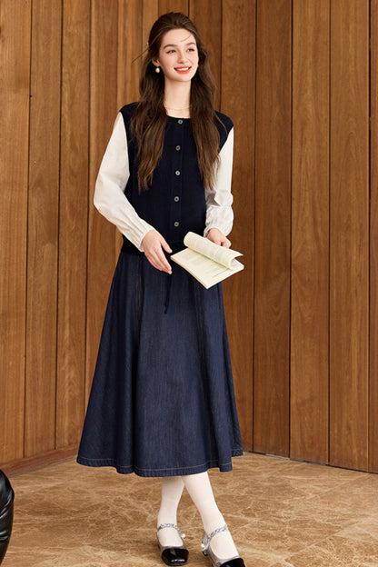 Standing pose of model in navy blue vest outfit with white blouse and maxi skirt