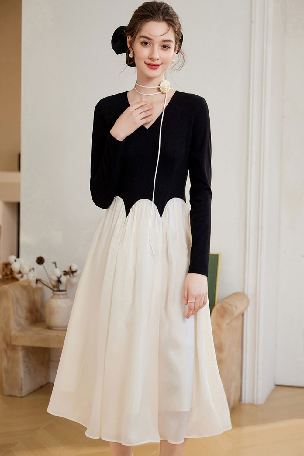 Front view of black top and white skirt outfit with V-neckline detail