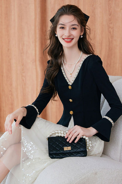 Sitting view of black blazer paired with white midi dress, accessorized with a clutch bag