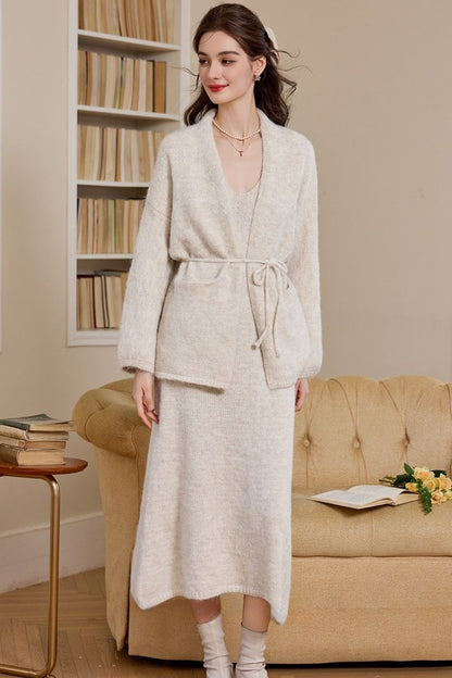 Front view of woman wearing a cream long knit cardigan dress with waist tie