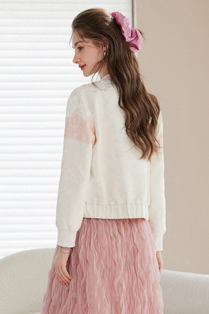 Back view of a woman wearing a white cardigan with pink gradient accents and a long pink ruffled skirt, hair tied with a pink ribbon