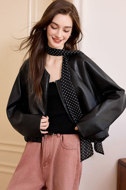 Model standing in black faux leather jacket with open front