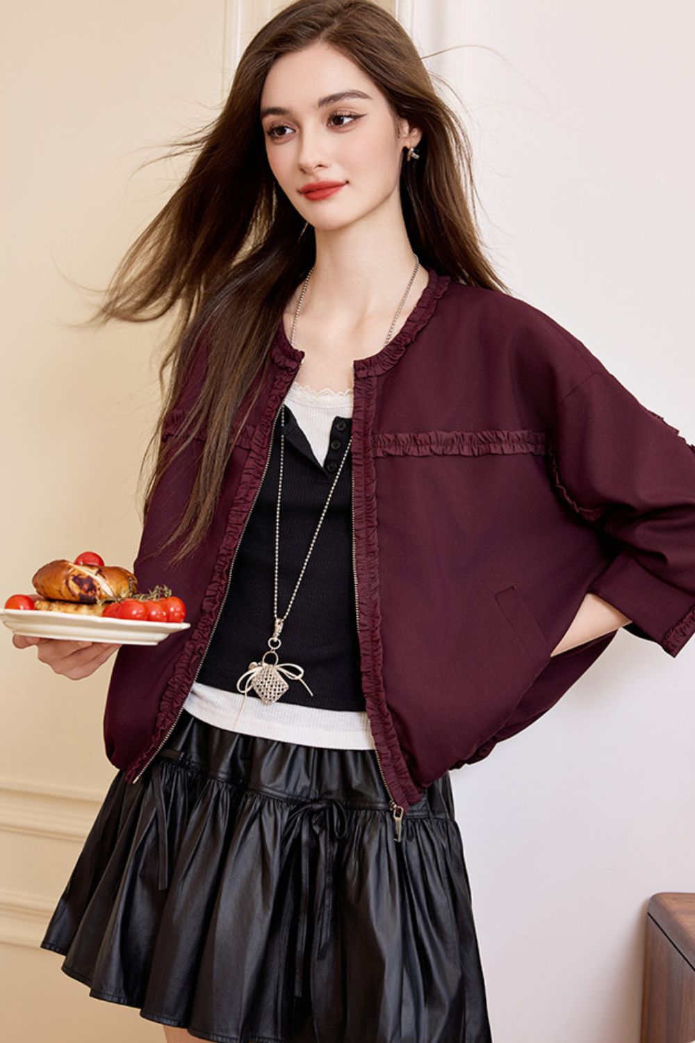 Side view of burgundy jacket styled with skirt