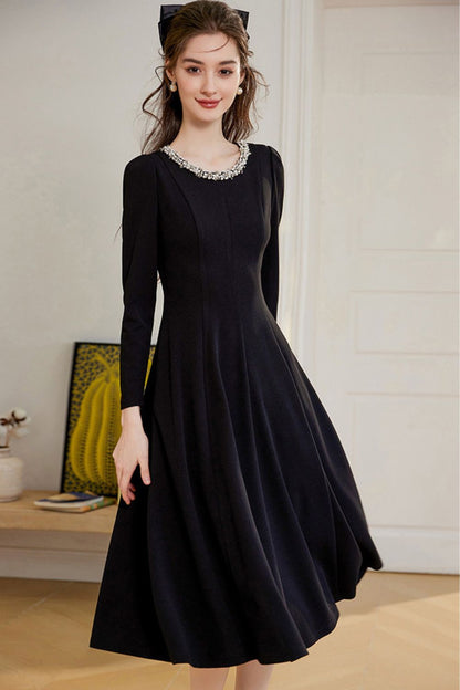 Side view of long-sleeve black midi dress with flared hem