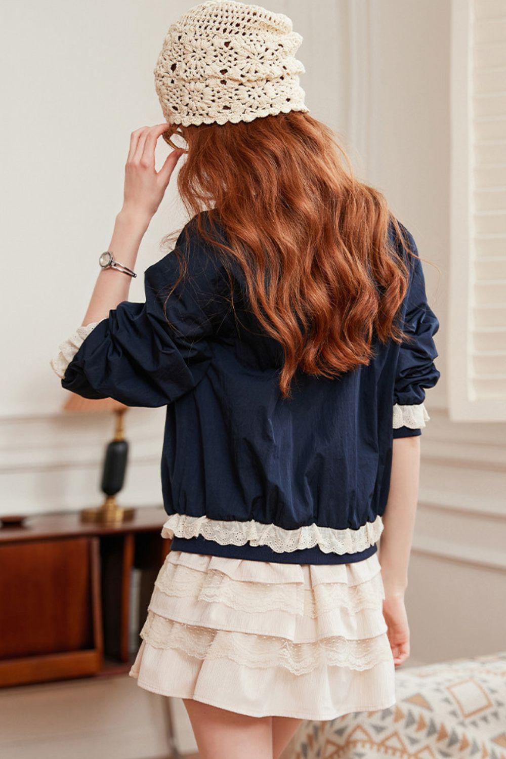 Back view of navy blouse with lace-trimmed collar, paired with beige skirt