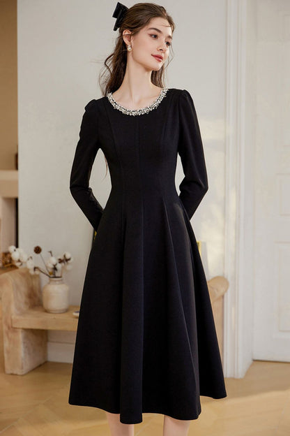 Angled view of black midi dress highlighting flowy skirt