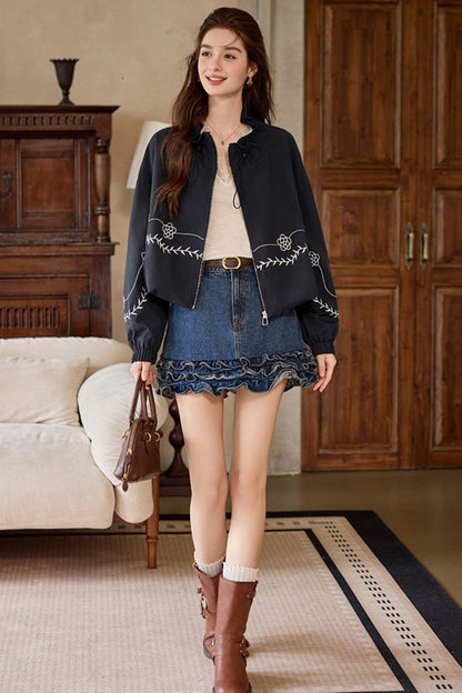 Full front view of outfit with black embroidered jacket and denim skirt