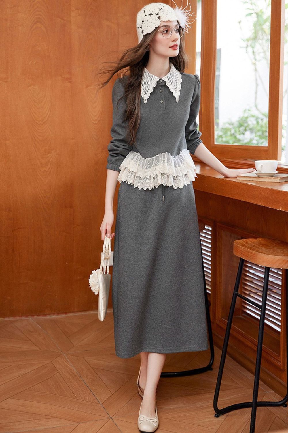 Model wearing gray lace-trimmed blouse with maxi skirt, holding a crochet bag