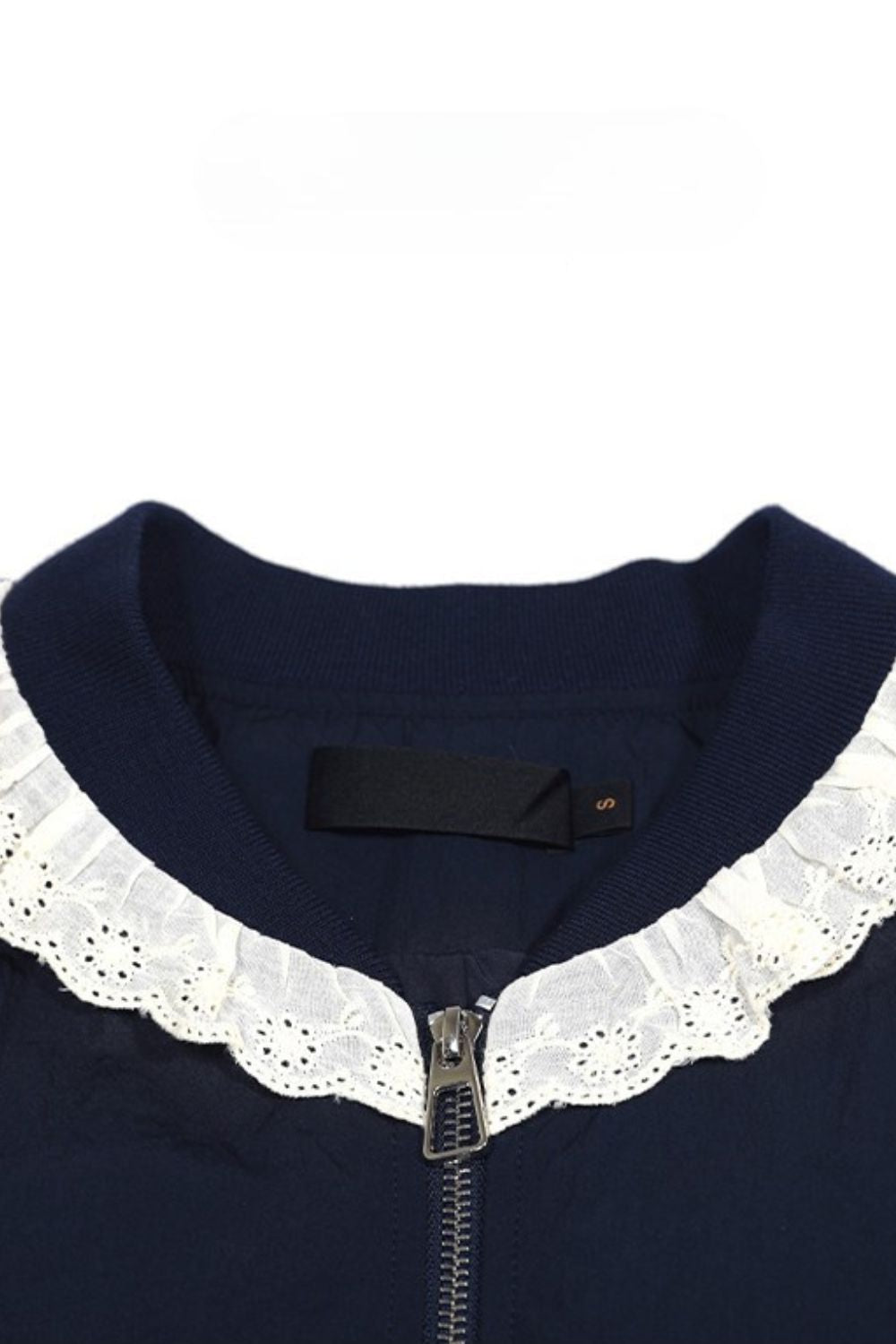Close-up of navy blouse collar featuring white lace trim detail