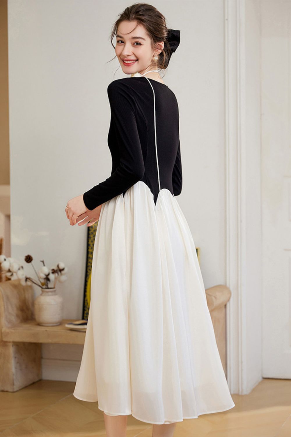 Back view of black and white midi dress styled with black heels