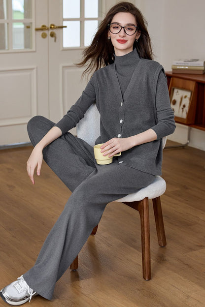 Smiling model seated in dark gray knit lounge set with wide-leg pants