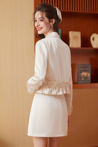 Back view of cream embroidered tassel jacket with cream mini skirt