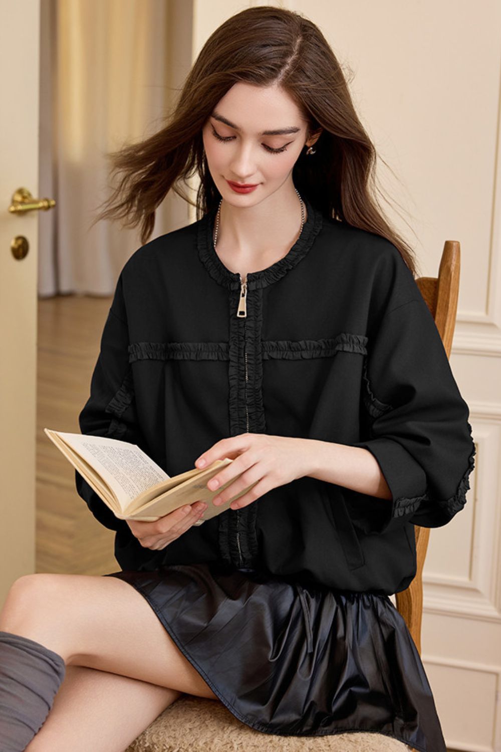 Seated view of black jacket with skirt